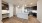 Kitchen with built in desk with brown cabinets, white quartz coutners and stainless steel appliances